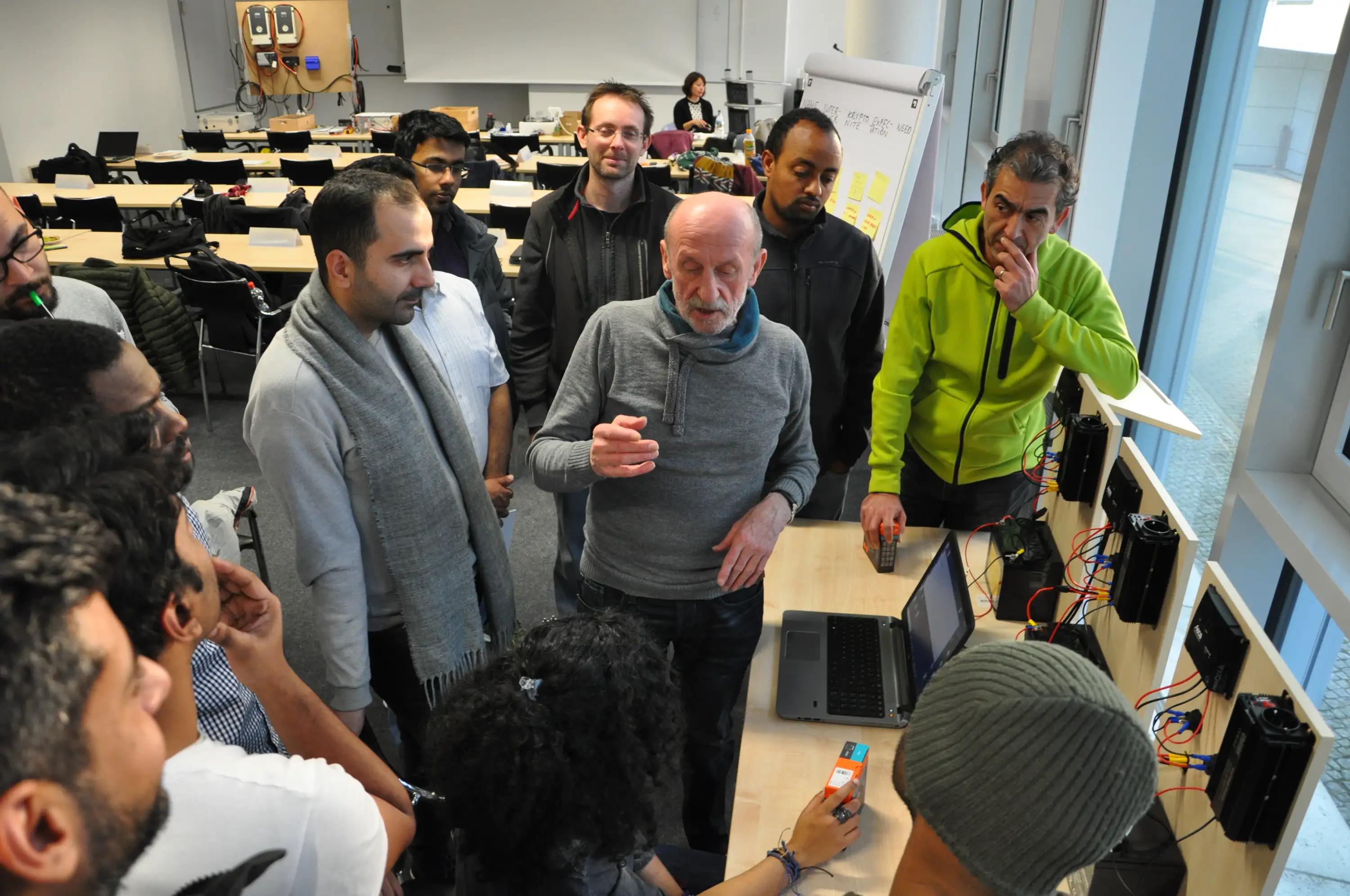 Professor explaining concepts about solar panels to students in solar energy academy.